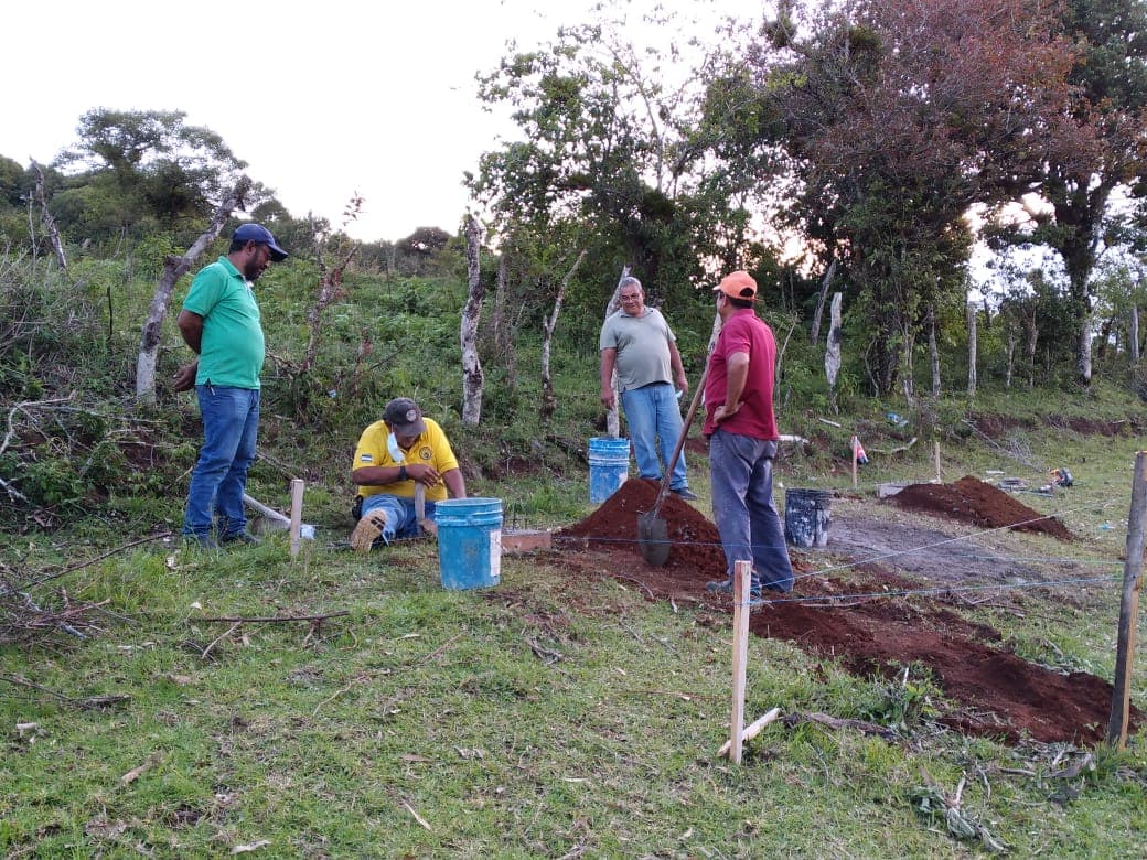 Miembros del club conversan durante una jornada de trabajo en campo.